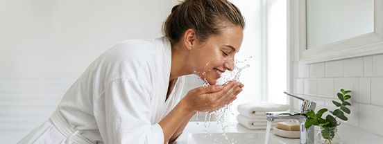 Frau mit gesunder Haut – ausreichend Wasser trinken für Haut und Verdauung